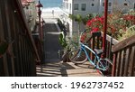 Blue bicycle, cruiser bike by ocean beach, pacific coast, Oceanside California USA. Summertime vacations on sea shore. Vintage cycle near wooden stairs, stairway access. Staircase, tropical palm trees