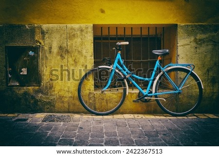 The blue bicycle waits for its owner tied with a chain
