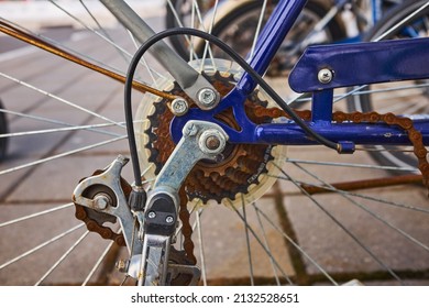 Blue Bike Has Been Outside All Winter And Got Broken. Rusty Bicycle Chain Hangs On Sprocket And Gear.