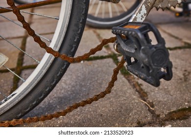 Blue Bike Has Been Outside All Winter And Got Broken. Rusty Bicycle Chain Hangs On Sprocket And Gear.