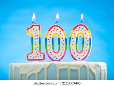 Blue Birthday Cake With 100 Candles On Top On A Blue Background 