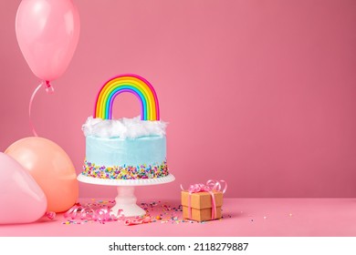 Blue Birthday Cake With Party Balloons And Gift On Pink