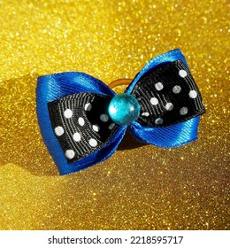 Blue With A Black Hair Bow Lies On A Golden Background. Side View. Accessories