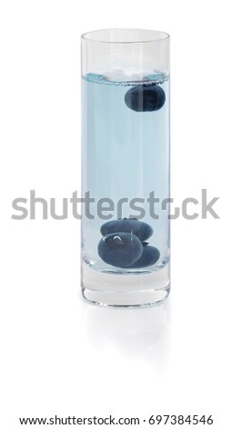 Blue blackberry shot drink isolated on a white background. An alcoholic beverage with a few dark blue berries.