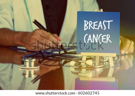Blue board easel written BREAST CANCER and a stethoscope, the doctor on duty behind. Medicine and Healthcare Concept