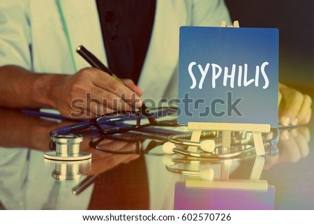 Blue board easel written SYPHILIS and a stethoscope, the doctor on duty behind. Medicine and Healthcare Concept