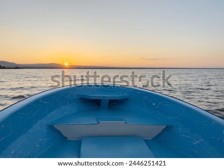 Blue boat bow on sunset background in orange color