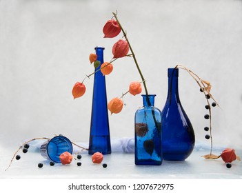 blue bottles and glass still life concept
