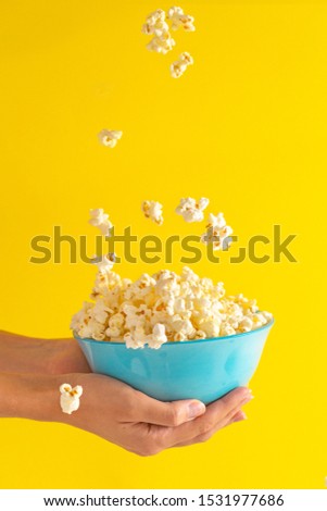 Similar – woman with popcorn in hand on yellow background. Copyspace