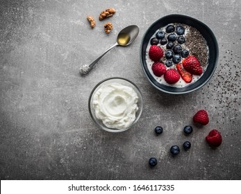 Blue Bowl With Yoghurt And Fruits. Spoon With Honey, Walnuts And Chia Seeds. Overhead Shot.