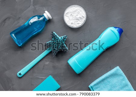 Blue brush in a star shape, powder, cloth and cleaner for gray background.  Flat lay, top view.