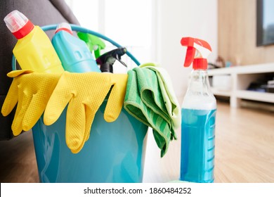 Blue bucket for cleaning with yellow gloves and a variety of detergents with rags. Room cleaning.Bucket with cleaning items on light background - Shutterstock ID 1860484252