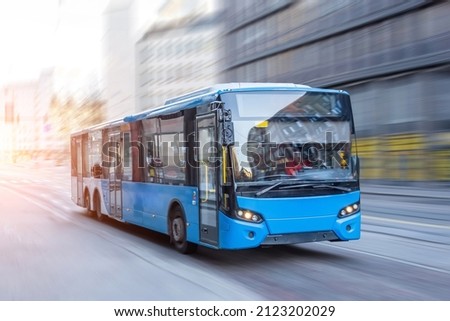 Blue bus moving on the road in city in early morning