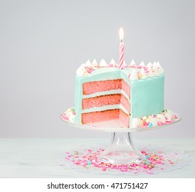 Blue buttercream birthday cake with pink layers and sprinkles.