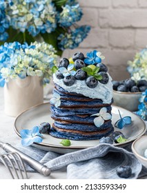 Blue Butterfly Pea Tea Pancakes served with whipped ricotta cream, blueberries and fresh blue hydrangea flowers
