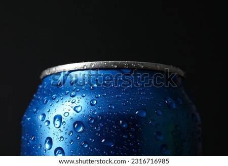 Blue can of fresh soda with water drops on dark background, closeup
