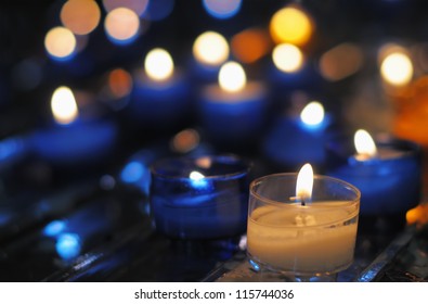 Blue Candles In Catholic Church With Blurred Background