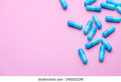 Blue Capsule Pills On Pink Background. Blue Capsule Pills With Copy Space. Pharmaceutical Industry. Community Pharmacy Product. Drug Use In Pregnancy Woman And Lactation And Elderly People Topics.