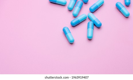 Blue Capsule Pills On Pink Background. Blue Capsule Pills With Copy Space. Pharmaceutical Industry. Community Pharmacy Product. Drug Use In Pregnancy Woman And Lactation And Elderly People Topics.