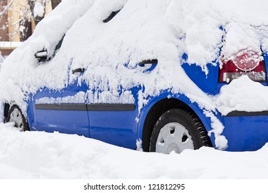 Blue car bogged down in the snow