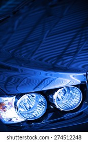 Blue Car Concept Photo. Blue Body Compact Car Hood And Headlight Closeup.