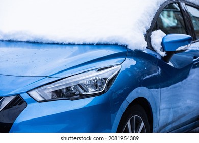 Blue car covered in snow. Winter morning. Snowy road.