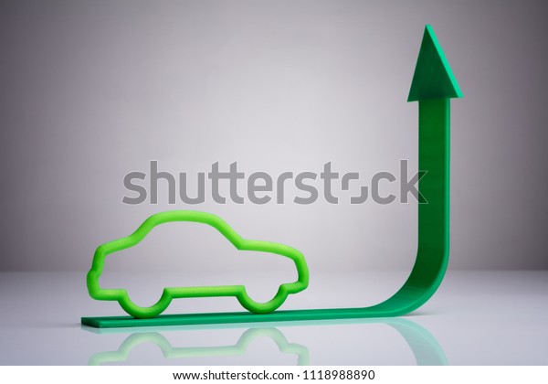 Blue Car Driving On Green Upward Arrow Against\
Gray Background