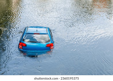Blue car drown in water canal. Extreme accident vehicle sink in river pound lake, traffic incident
