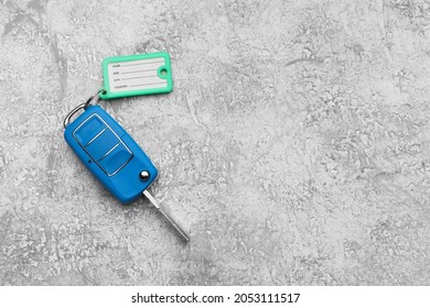 Blue Car Key With Plastic Tag On Grunge Background