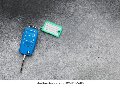 Blue Car Key With Plastic Tag On Grunge Background