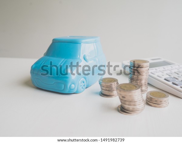 Blue car Piggy\
bank and calculator  with coins pile, Saving money for future plan\
and retirement fund\
concept.