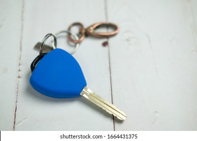 Blue car car remote alarm control key cover silicone with chain on wooden table.