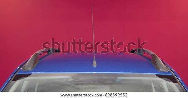 Blue car rooftop\
carrier with red\
background