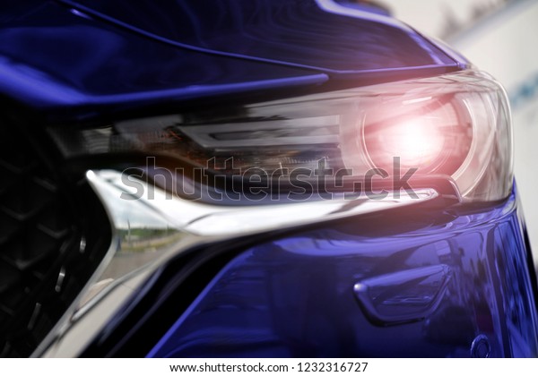 blue car shining\
headlights close up
