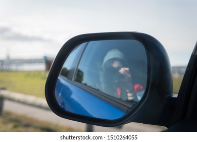 Blue Car Side Mirror With Blurred Mirror Selfie Of Woman Wearing Beanie Hat With Nature Coast Background