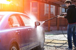 Cleaning car using active foam. Man washing his car on self car