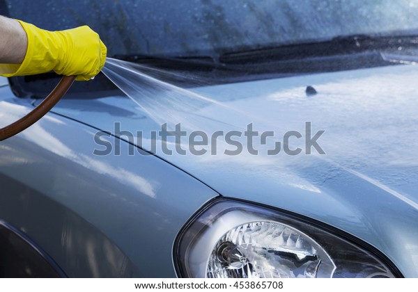 blue car is washing in soap\
suds