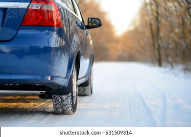 Blue Car With Winter Tires On The Snowy Road. Drive Safe Concept.