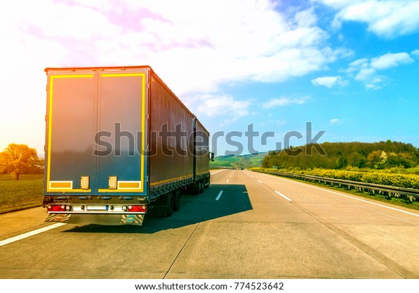 Blue cargo truck on an\
empty freeway
