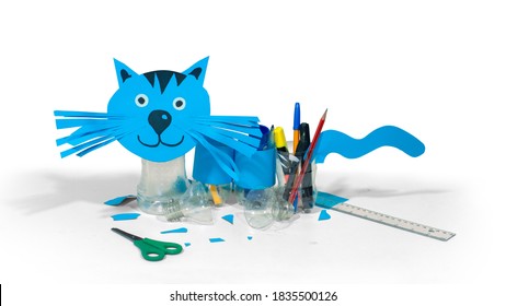 Blue Cat Made With Cardboard And Recycled Plastic Bottles That Can Be Used As Pencil Holders On Table With Scissors And Ruler On White Background