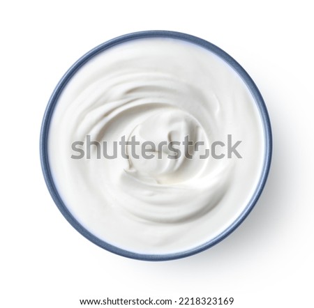 Blue ceramic bowl of fresh greek yogurt or sour cream isolated on white background, top view