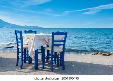 Blue chairs and table in typical Greek tavern near the sea in Kissamos town. Crete, Greece