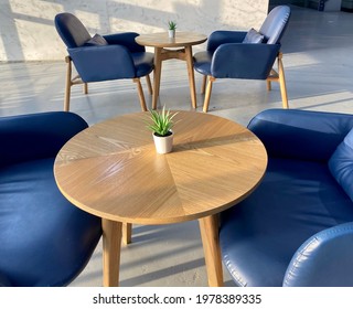 Blue chairs and wooden tables in a comfortable professional lounge area in natural light with no people - Powered by Shutterstock