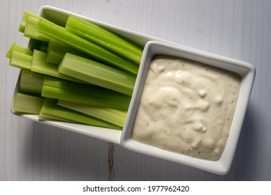 Blue Cheese Dipping Sauce And Celery Sticks In White Rectangular Dish.