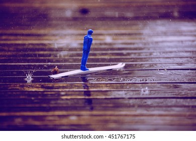 Blue Children's Ski Jumper Toy Heavy Rain On The Table In Finland. Image Includes A Vintage Effect.