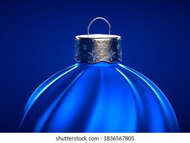 Blue Christmas ball with twisted stripes pattern. Closeup of Christmas ornament against blue background. Christmas decoration, festive atmosphere concept.