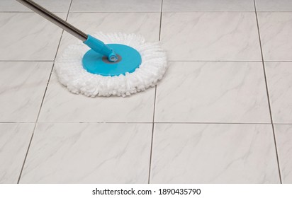 Blue Cleaning Mop On White Ceramic Tile Floor Background