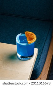 Blue cocktail with ice and decorated with an orange. - Shutterstock ID 2311016673