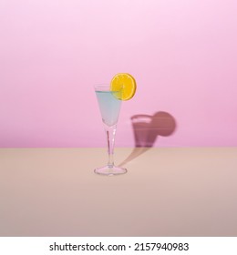 Blue Cocktail With Lemon On Pink And Beige Background. Summer Party And Dance.