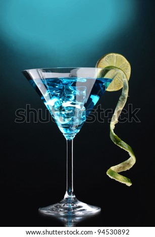Blue cocktail in martini glass on blue background